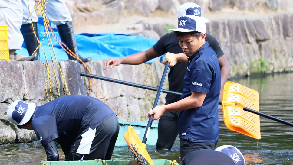 写真：水前寺公園の湧水池で、ボランティアが清掃作業を行っている様子